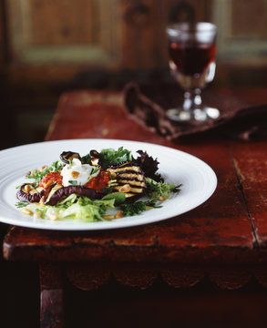 Grilled aubergine and pine nut salad with glass of red wine