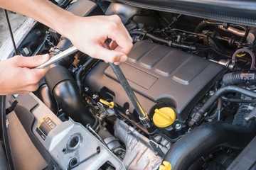 Hands repairing a modern car engine with a wrench