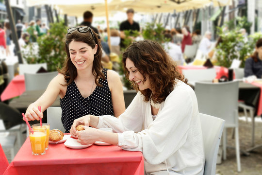 Smiling women sitting at outdoor cafe