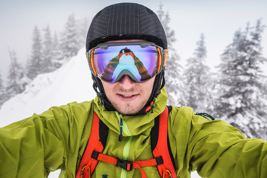 Close up of male skier wearing ski goggles taking selfie on mountain at Kranzegg, Bavaria, Germany