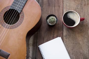 coffee cup and guitar on wooden table