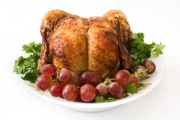 Garnished roasted turkey with grapes and herbs isolated on white background

