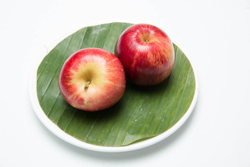 Red apple's two on with banana leaves