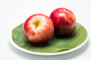  Red apple's two on with banana leaves
