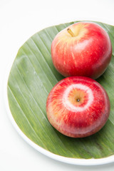  Red apple's two on with banana leaves