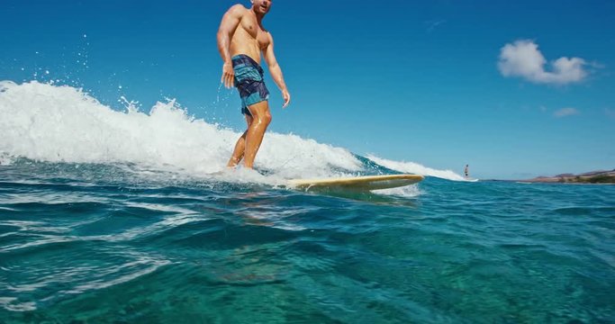 Young man having fun surfing, riding ocean wave in slow motion
