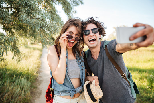 Cheerful couple w hiking in the forest and making selfie