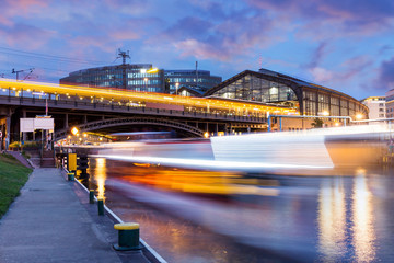 Berlin at night with boat on the River Spree and train on the bridge 