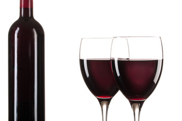 Zwei gefüllte Rotweingläser und eine Rotweinflasche vor weißem Hintergrund, Makro, Freisteller