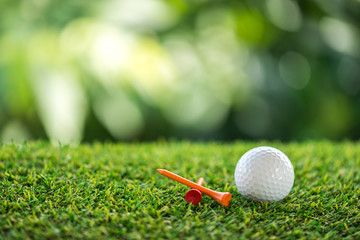 golf ball and wooden tee on grass