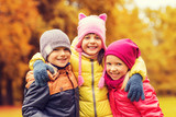 group of happy children hugging in autumn park