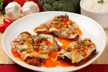 Fillet of beef parmigiana, vegetables in the background