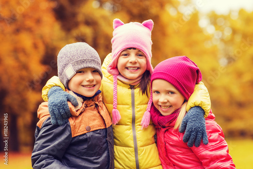 group of happy children hugging in autumn park