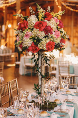 Greenery twines around the wooden sticks on which stand a pink b