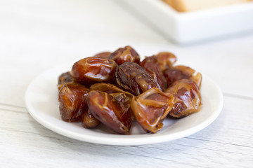 White ceramic dish with a group of dates palm