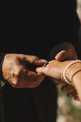 Obraz premium Groom puts a precios wedding ring on delicate bride's hand