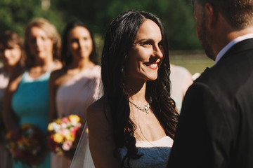 Evening sun lies a shadow on a beautiful bride admiring a groom