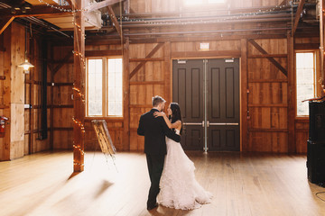 Cheerful newlyweds dance in the middle of wedding hangar prepare