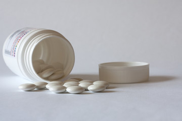 Pills from a jar on a light background