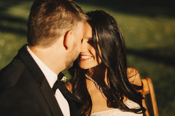 Bride's brunette hair shines under the sunrays while she sits wi