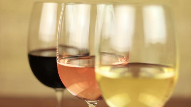 White wine, rose wine and red wine on yellow background with focus changes