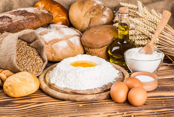 Assortment of baked bread on wooden table background