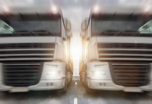two plain trucks on a highway speed blur