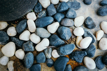 black and white stones over cropped image of ceramic pot
