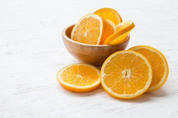 Orange slices in bowl on white rustic wooden table