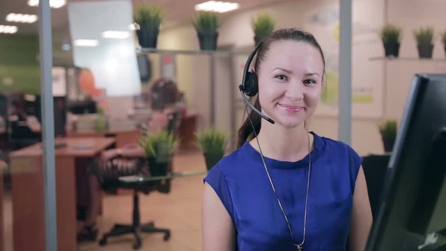 Caucasian woman at a Call center in a bright clean office. HD.