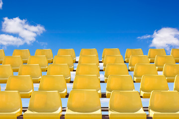 Yellow colorstadium chairs with blue sky
