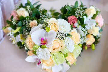 Flower heart made of orchids, roses and greenery