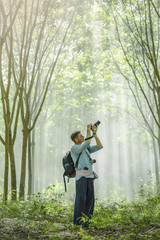 Happy the young man  taking a photo in rubber plantation
