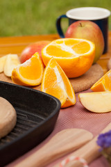 Various wood made utensils, knife,fork,spatula put on decorated table with fruit and flower