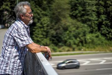 Mann schaut von der Brücke auf die Autobahn