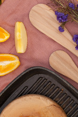 Various wood made utensils, knife,fork,spatula put on decorated table with fruit and flower