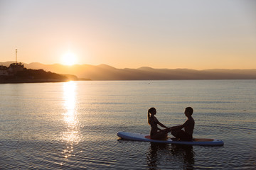 Naklejka na ściany i meble Silhouette of perfect couple engage standup paddle boarding