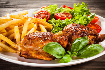Grilled chicken legs with chips and vegetables 