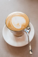 A glass of latte art coffee in coffee shop