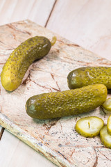 Dill pickles on a cutting board.