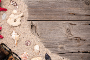 Sea shells with binocular on sandy wooden background