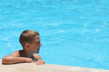 A young boy playing in a swimming pool while on vacation, 2016