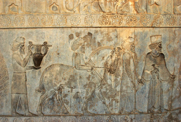 Residents of historical empire with animals. Stone bas-relief in ancient city Persepolis, Iran....