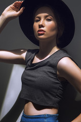 High fashion look.glamor closeup portrait of beautiful stylish Caucasian young woman model with perfect clean skin in big black hat
