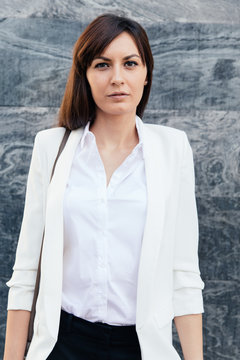 Successful businesswoman in white shirt looking away