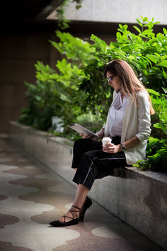 Businesswoman with coffee using tablet