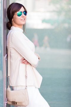 Attractive businesswoman in sunglasses smiling away in the street