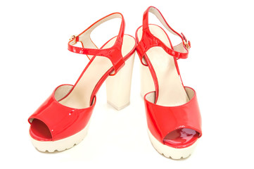 Pair of red womens high heeled shoes on white background.