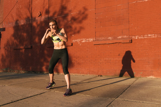 Young woman exercising outdoors, shadow boxing, Brooklyn, New York, USA