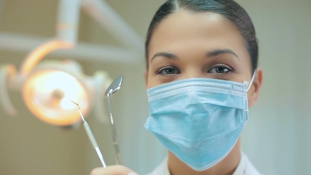 Portrait of a dentist in mask with tools